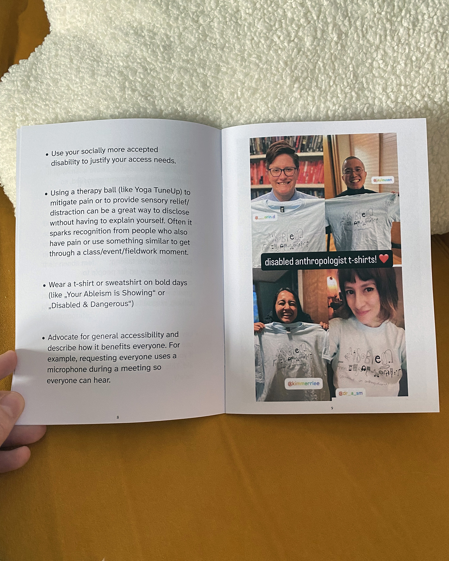 The booklet lies opened on a soft couch, propped up against a cloud shaped fuzzy pillow. The opened pages show advice in bullet points on the left side. The first bullet point reads: Use your socially more acceptable disability to justify your access needs. On the right side, there is a photo collage of four photos of smiling people with a light blue tshirt that reads disabled anthropologist where each letter represents something related to diverse disability communities with disabled, um, anthropologist written below as a translation. The person on the top left is a white nonbinary scholar with shirt brown hair and glasses with books behing them. On the top right, an Asian man with close-cropped hair, glasses, and a crutch hold up his t-shirt. The bottom left is a brown nonbinary South Asian scholar with black hair. On the bottom right is a selfie of a light-skinned Mestiza scholar with short brown bobbed hair and bangs wearing her tshirt.